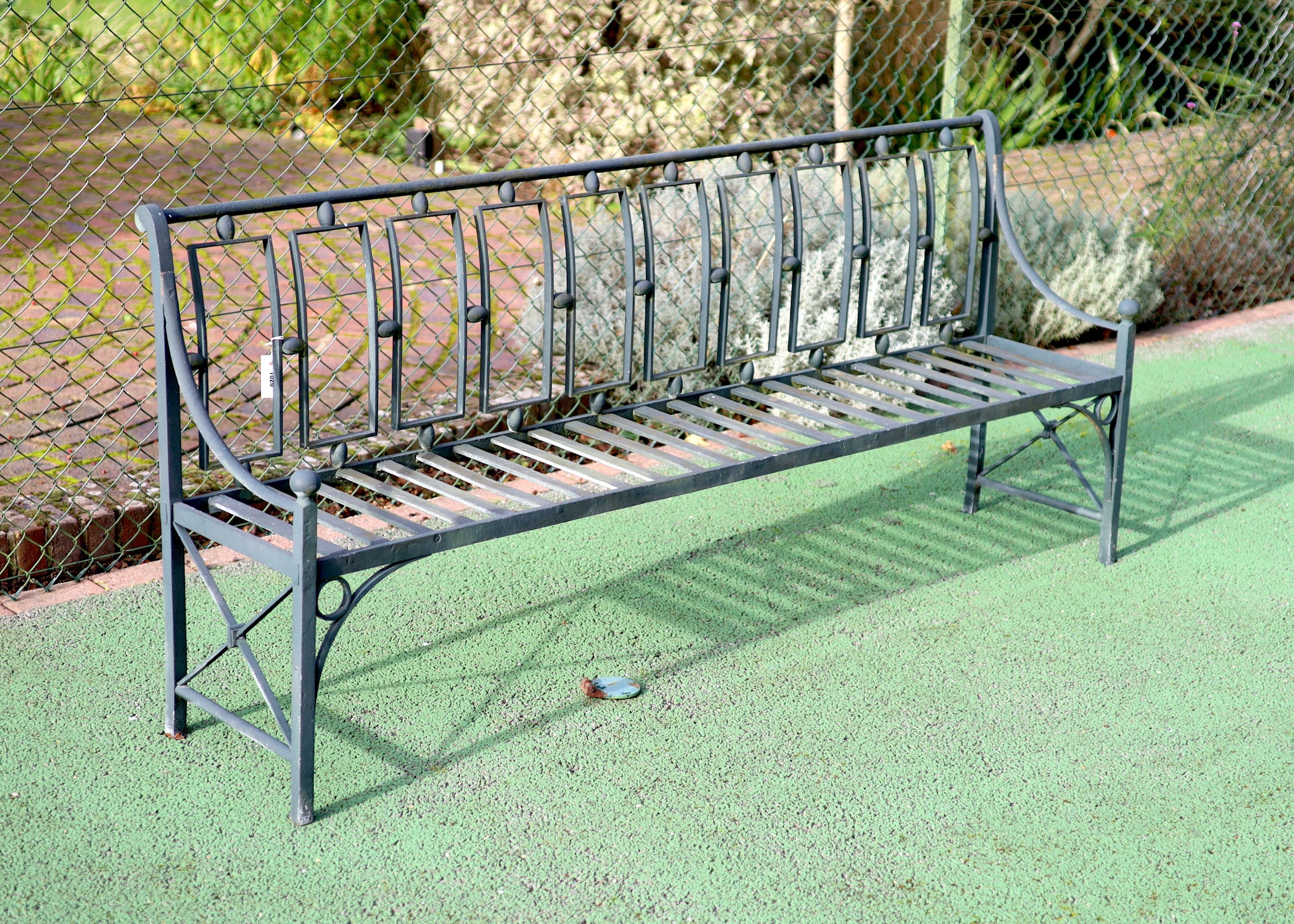 A green painted wrought iron garden bench, W.204cm D.49cm H.87cm